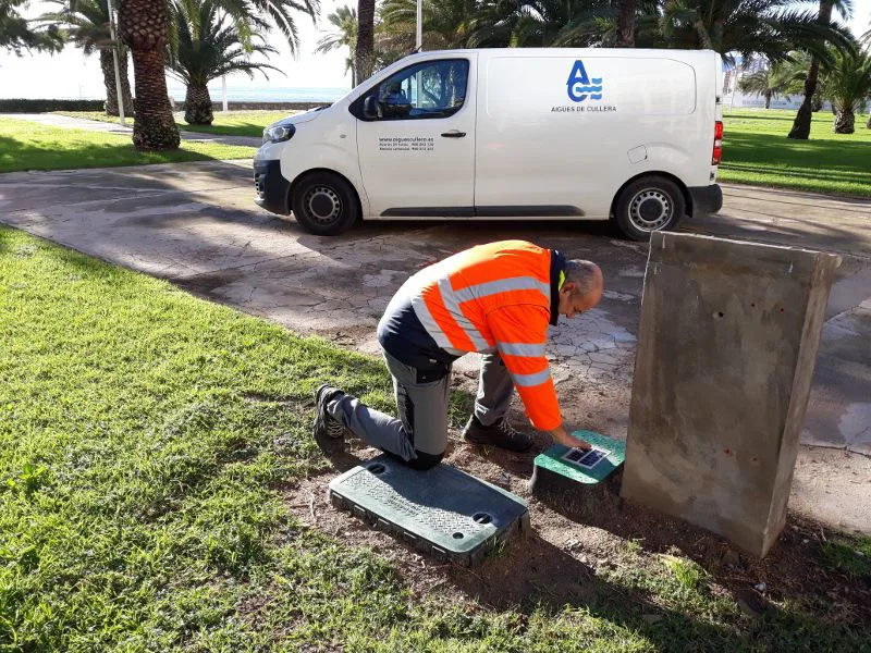 Technician installing a Smart Biosystem unit in the ground with an Aigues de Cullera van behind